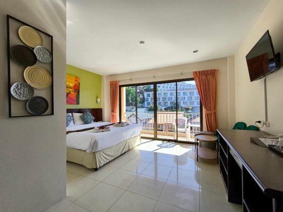 Seven Seas Hotel Patong Beach：带阳台和休息区的客房卧室